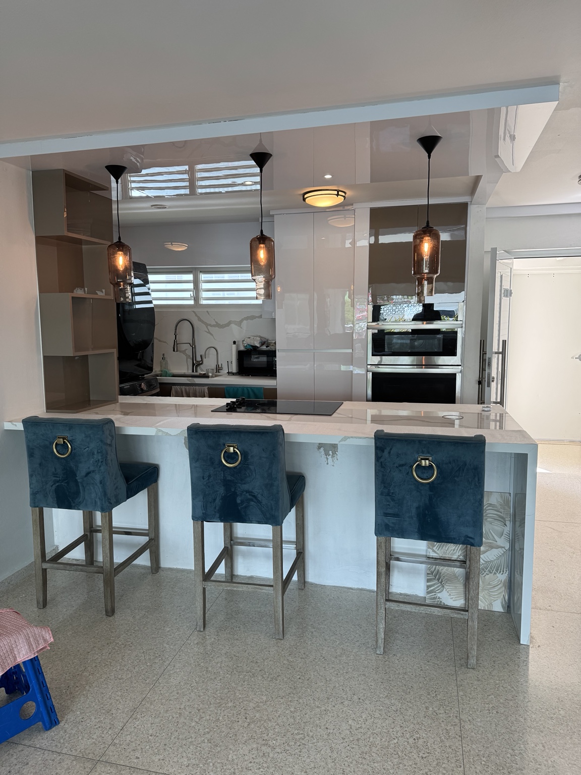 Cocina moderna con isla blanca y butacas azules